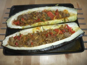 Photo de deux 1/2 courgettes farcies à la viande hachée avec poivrons et tomate