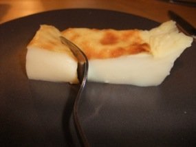 Photo d'une parte de flan qui se faire couper par une fourchette à dessert